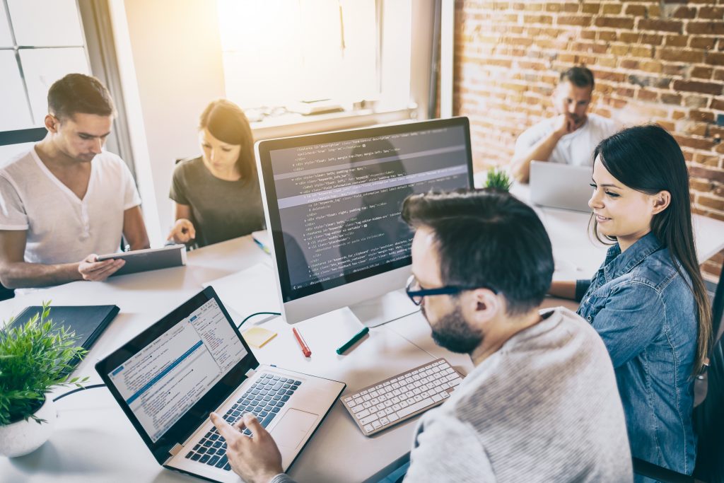 Web designers in office discuss code